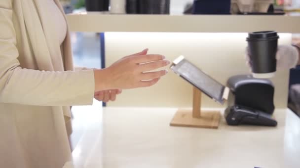 La mujer toma una taza de papel en el mostrador de pago en la cafetería para llevar. Primer plano plano de las manos
 - Metraje, vídeo