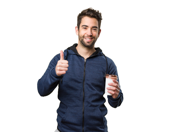 young man holding a coffee and doing okay gesture isolated on white background - Фото, зображення