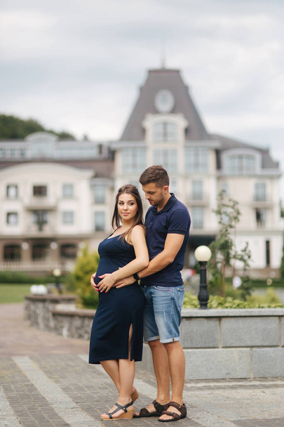 Pregnant woman and her husbant hug each other and smile - Foto, Imagen