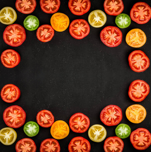 Tuoreet, mehukkaat tomaatit leikataan kahtia järjestetty kehyksen muotoon musta pöytä, vihannesten tausta, jossa on tilaa kirjoittamiseen
 - Valokuva, kuva