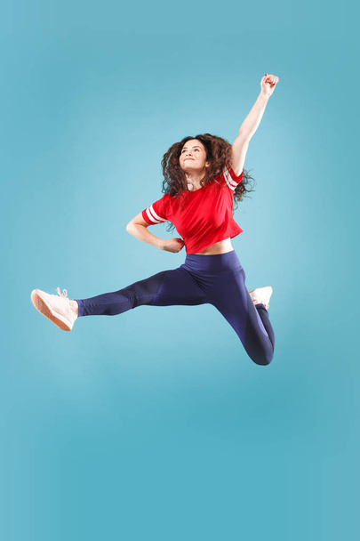 Freedom in moving. Pretty young woman jumping against pink background - Foto, Bild