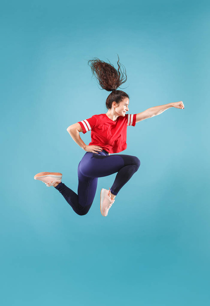 Freedom in moving. Pretty young woman jumping against pink background - Foto, afbeelding
