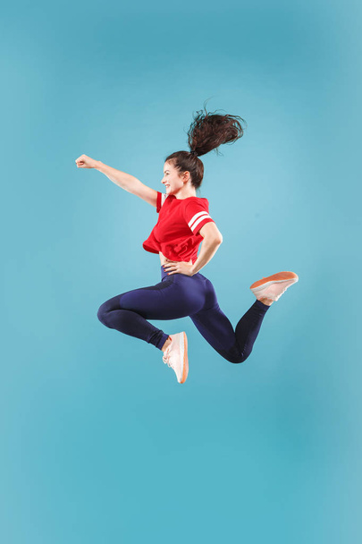 Freedom in moving. Pretty young woman jumping against pink background - Фото, зображення