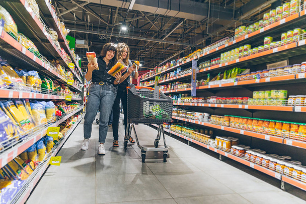 LVIV, UKRAINE - 8 septembre 2018 : deux femmes choisissent des produits en épicerie
 - Photo, image