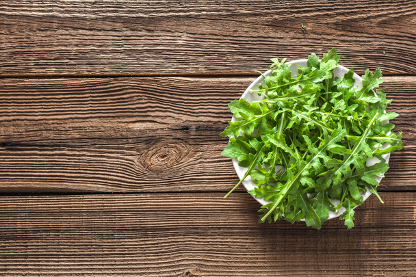 Fresh arugula on plate, leaves of green plants for salad, organic food on table - Foto, imagen