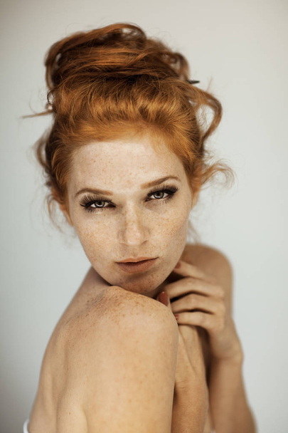 Portrait of a beautiful young woman with long red curly hair and freckles, perfect make up - Photo, image