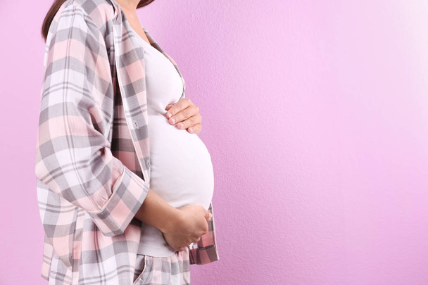 Pregnant woman posing on color background, closeup. Space for text - 写真・画像