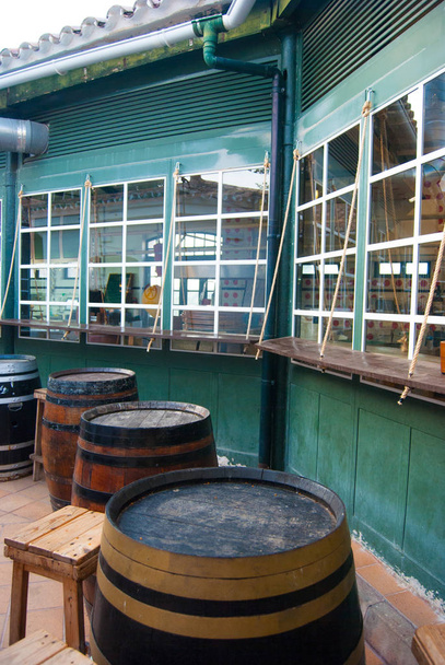 Cuatro barriles grandes y viejos con taburetes altos de madera
 - Foto, Imagen