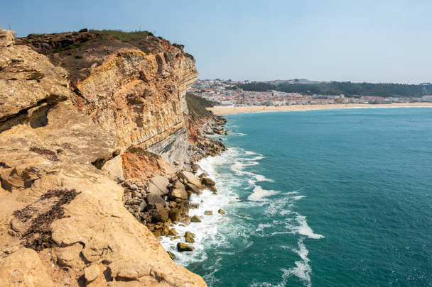 ナザレ、ポルトガル - 2018 年 9 月 20 日: 緑金色の石崖海と背景ナザレ、ポルトガルのナザレの村 - 写真・画像