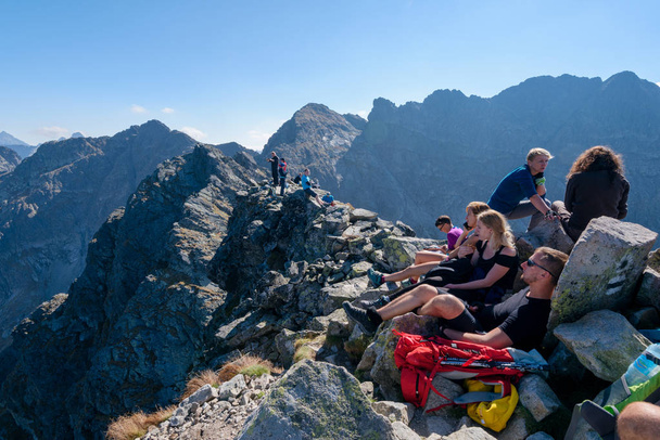 Hikers resting on the Koscielec peak in the High Tatras, Poland - Foto, afbeelding