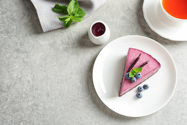 Flat lay composition with piece of tasty blueberry cake and space for text on gray table - Photo, image