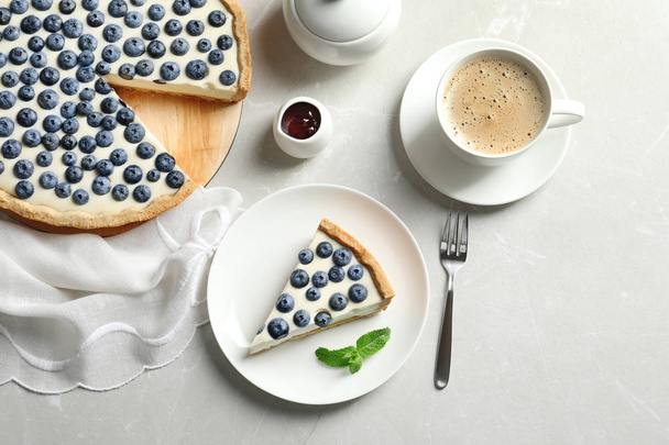Flat lay composition with piece of tasty blueberry cake on gray table - Foto, Bild