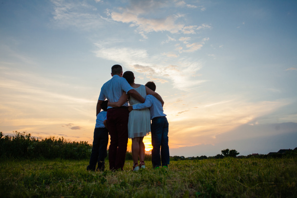 Happy family on the background of the sunset - Fotografie, Obrázek