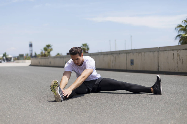 Muscular man stretching outdoors - 写真・画像