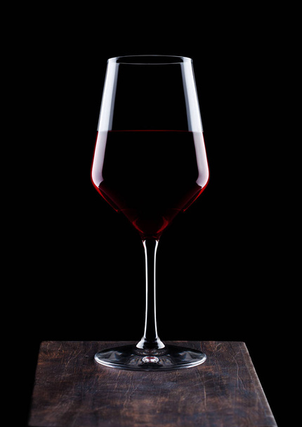Glass of red wine on wooden board on black background.  - Φωτογραφία, εικόνα