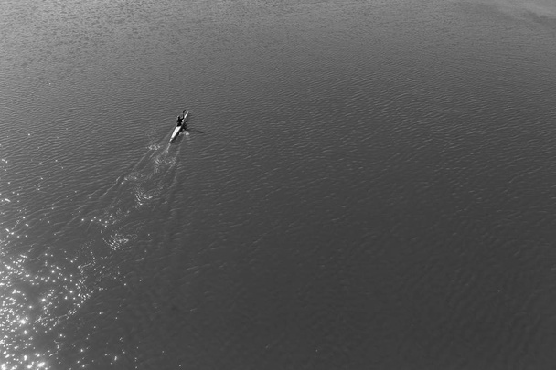 Два гребца каноэ утренняя практика вверх по стеклянным речным водам птиц глаз над головой ландшафт
 - Фото, изображение