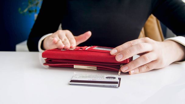 Nahaufnahme Foto einer jungen Frau mit großer roter Brieftasche und Kreditkarten - Foto, Bild