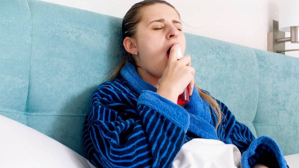 Portrtaif of sick woman with flu using sore throat spray - Photo, Image