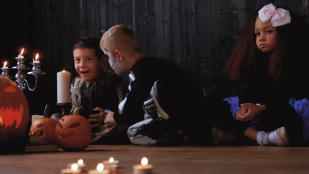 Groupe d'enfants multiraciaux mignons en costumes effrayants pendant la fête d'Halloween dans une vieille maison
. - Séquence, vidéo