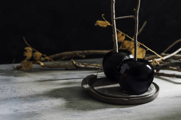 schwarze Karamell-Äpfel, verzehrfertig zum Herbst-Snack zu Halloween - Foto, Bild