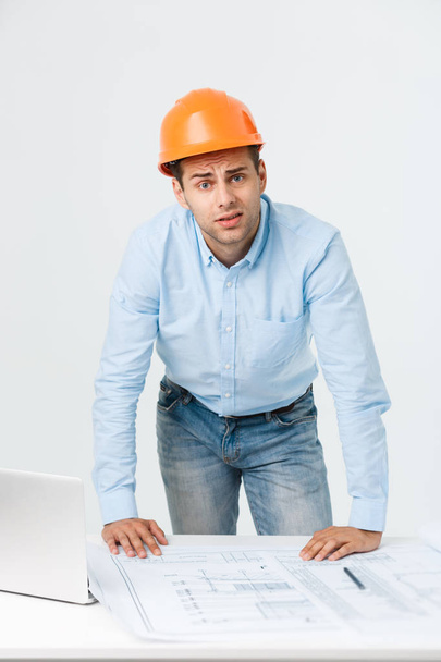 Stressed young constructor having headache or migraine looking exhausted and worried isolated on white background with copy space - Foto, Bild