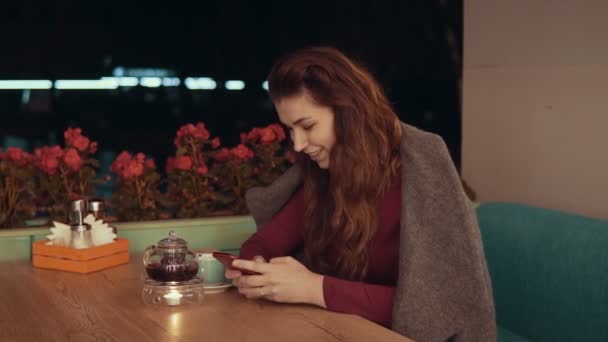 Woman using app on smartphone in cafe and texting on mobile phone with copyspace - Materiał filmowy, wideo