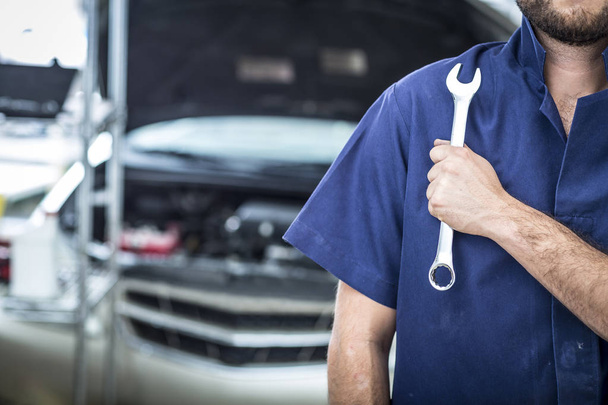 Mechanic hand checking and fixing a broken car in car service garage - Zdjęcie, obraz