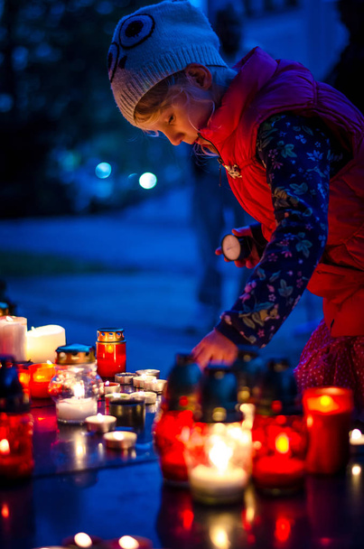 dítě hořící svíčka během všech svatých na hřbitově v temné noci  - Fotografie, Obrázek