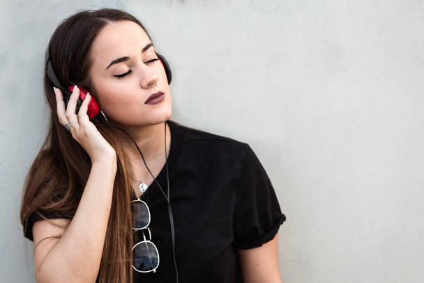 Красива молода жінка з закритими очима слухає музику
 - Фото, зображення