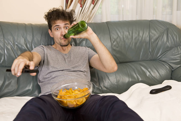 Man relax after work watching tv and drinking beer - Photo, image