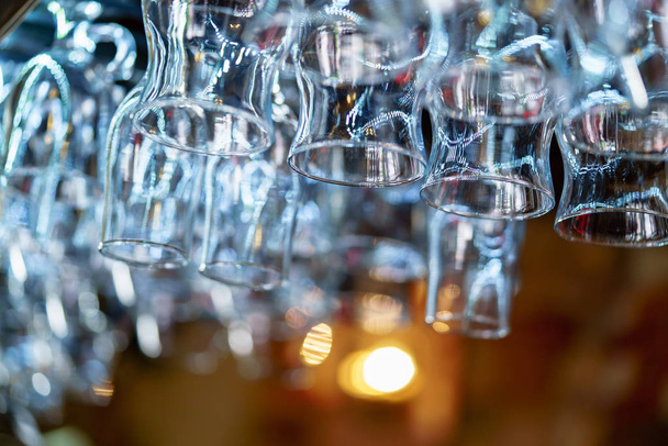 large quantity of wineglasses hang at the bar in the cafe. Close-up - Photo, Image