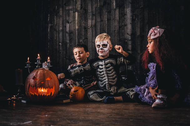 Group of cute multiracial kids in scary costumes during Halloween party in an old house. - Photo, Image