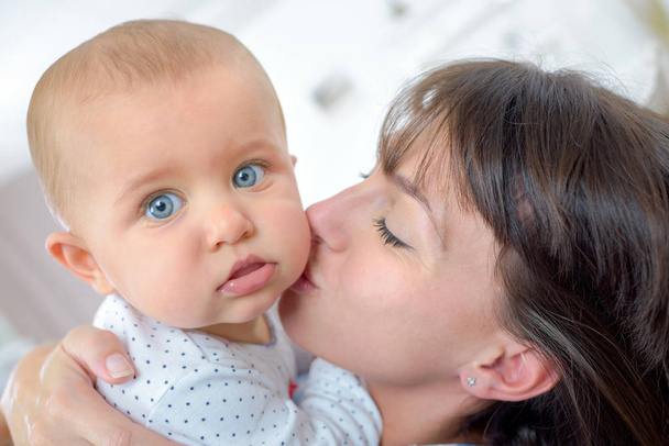 Mother kissing baby and mother - Φωτογραφία, εικόνα