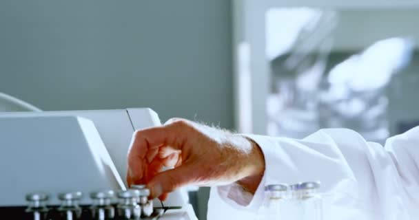 Male scientist placing medical vials on a rack in laboratory 4k - Imágenes, Vídeo