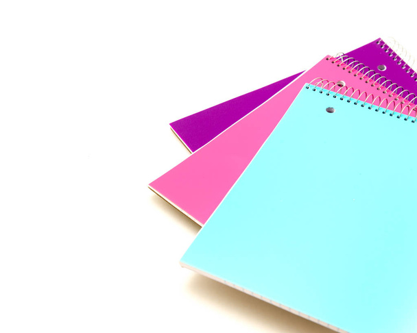Top view studio shot three 1-subject notebooks isolated on white background. Colorful assortment classroom classic college-ruled notebooks with 3-hole punched to fit standard binder, back to school - 写真・画像
