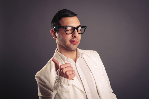 Funny portrait of young nerd with eyeglasses on grey background. - Fotografie, Obrázek