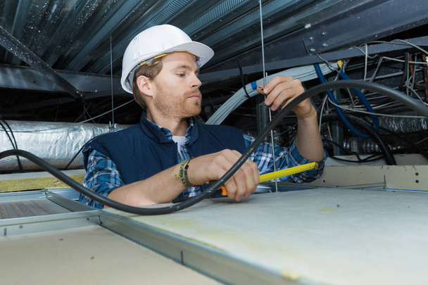 electricista instalando un cable para luz de techo - Foto, Imagen