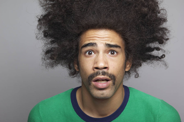Yllättynyt musta mies, jolla on isot hiukset
 - Valokuva, kuva
