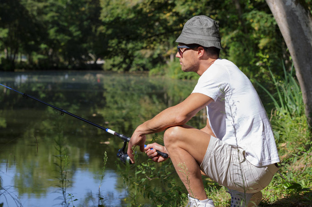 man with a fishing rod at the lake - Zdjęcie, obraz