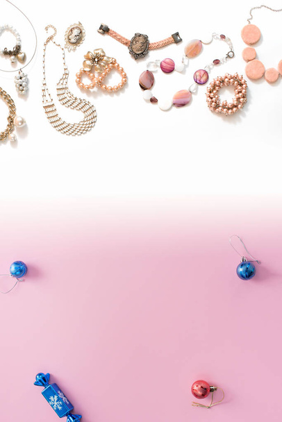 Vánoční složení plochý ležel koule šperky náhrdelník náramek vintage perly růžové přechodu pozadí bílé až modré. Pohled shora kopie prostoru vertikální - Fotografie, Obrázek