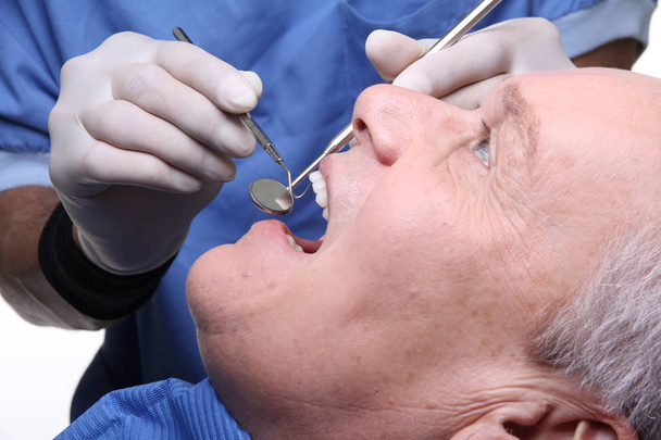 Old caucasian man treats a tooth at the dentist - Zdjęcie, obraz