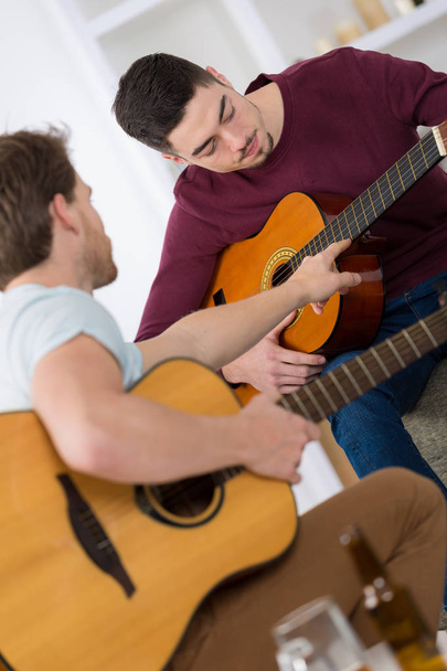 handsome young men playing guitar - 写真・画像