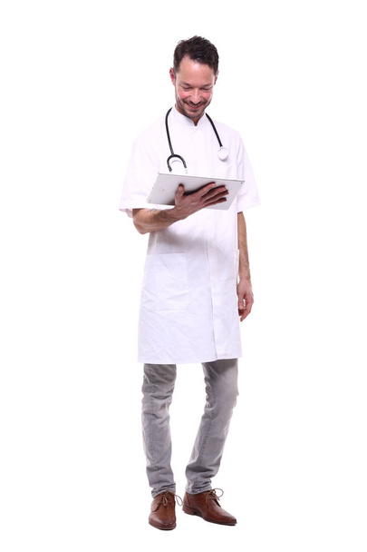 Male doctor wearing special uniform with stethoscope and using tablet PC - 写真・画像