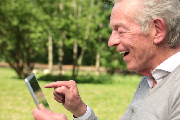 Vecchio uomo caucasico utilizzando tablet PC
 - Foto, immagini