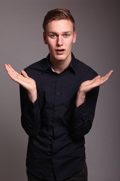 Caucasian young man is gesticulating with hands - 写真・画像