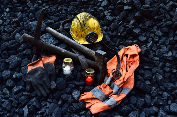 Wake licht, kaars met de bezittingen van de mijnwerker (helm, handschoenen, houweel, vest, riem) na het fatale ongeval in de mijn - Foto, afbeelding