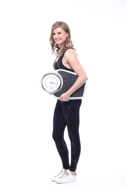 Young sportswoman is holding weight scale - Photo, Image