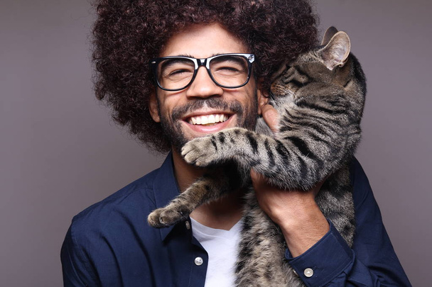 Black man holding cat in hands - Foto, Imagen
