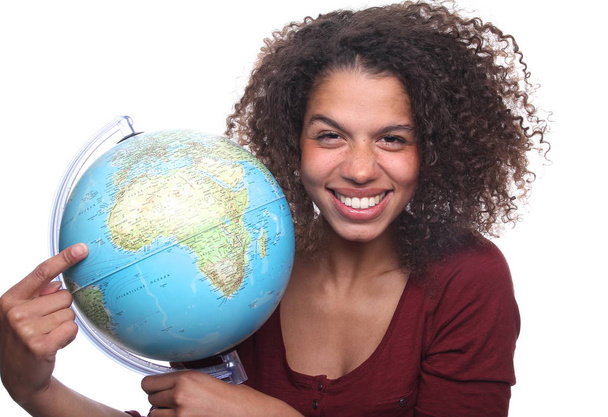 Happy black woman pointing on globe - 写真・画像