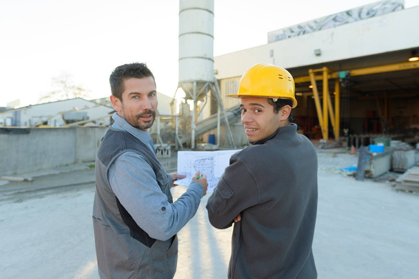 two engineers looking at camera at plant site - Fotó, kép